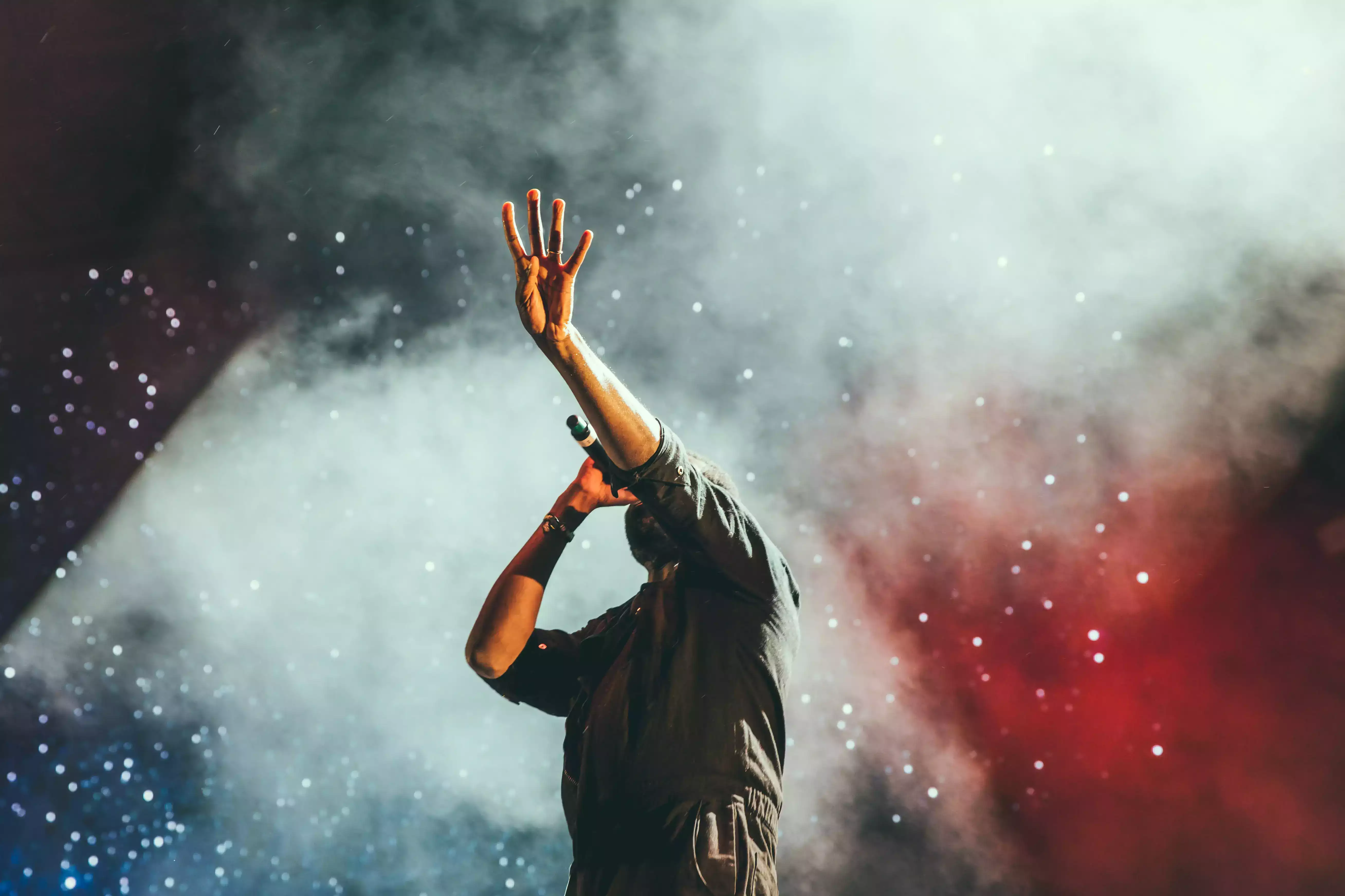 Photo d'un chanteur sur scene avec les tribunes derriere lui